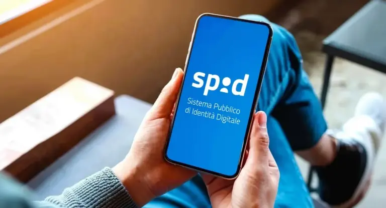 Persona tiene in mano uno smartphone con il logo SPID sullo schermo.