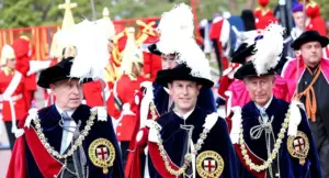 Persone in abiti cerimoniali con decorazioni e piume bianche durante un evento ufficiale