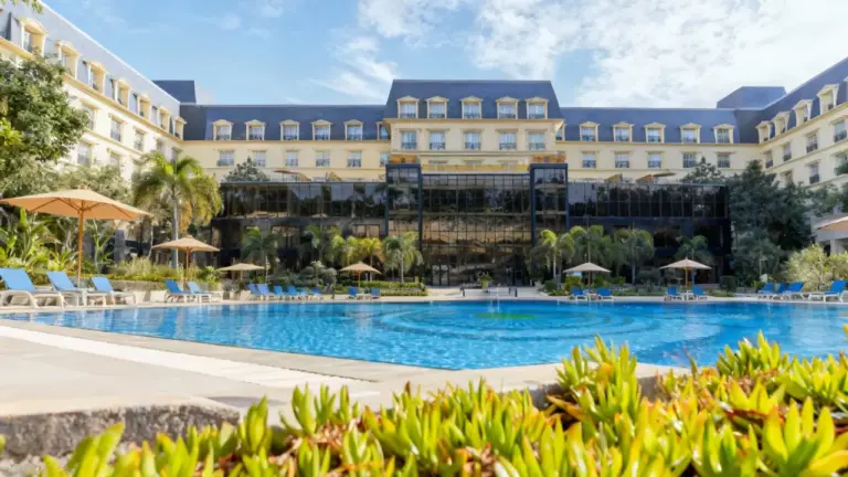 Vista di un lussuoso hotel con piscina all'aperto e ombrelloni