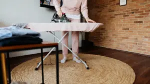 Persona che stira su un'asse da stiro in un ambiente domestico