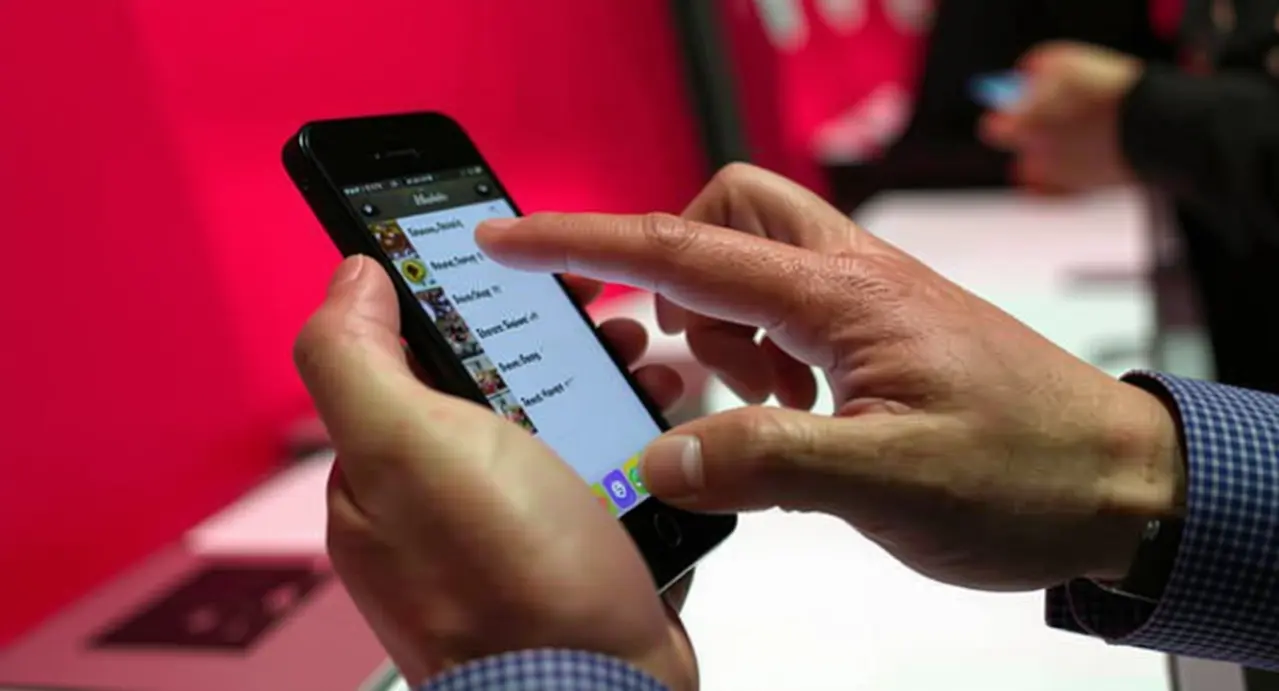 Mani che usano uno smartphone con un'app di messaggistica aperta