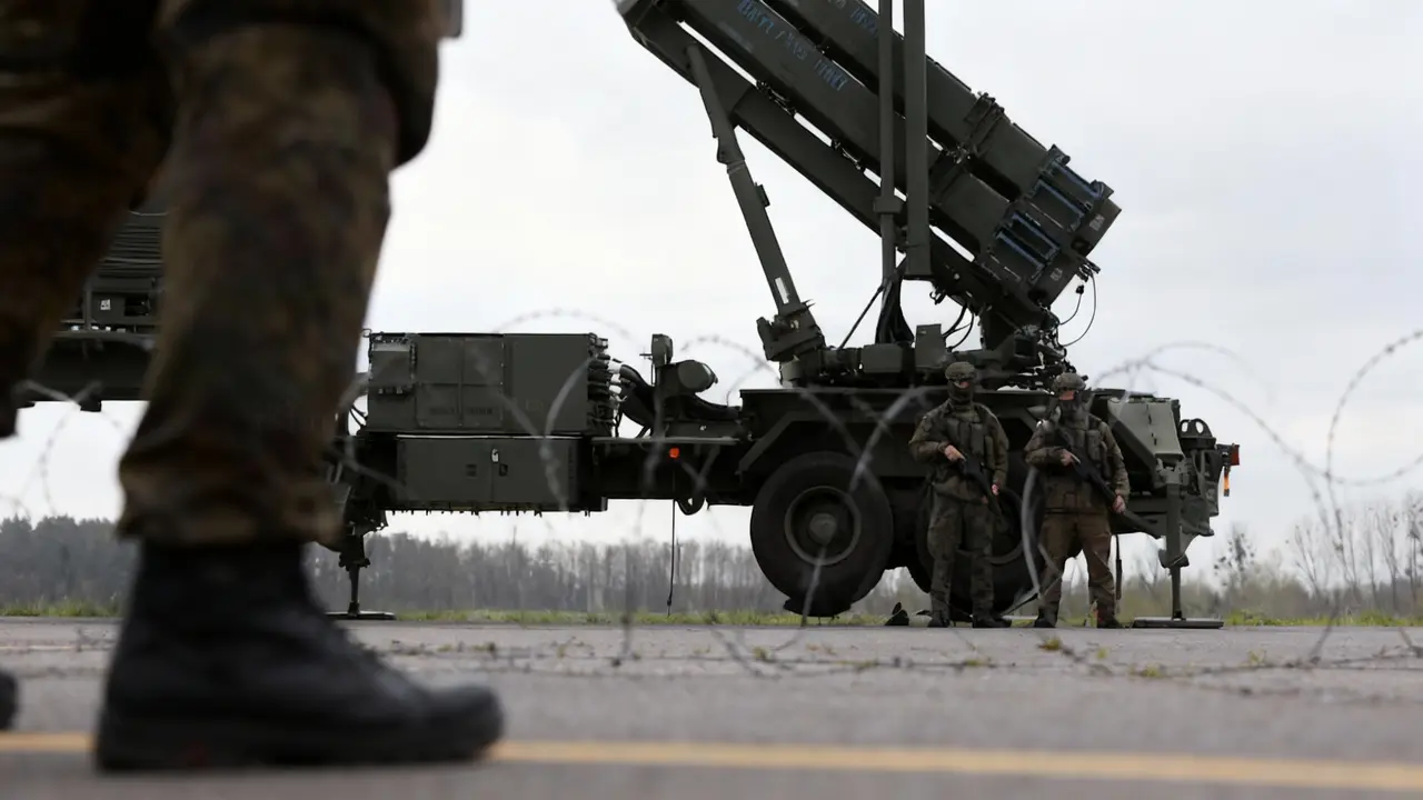 Soldati in uniforme davanti a un sistema missilistico Patriot su una pista asfaltata