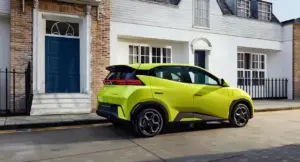 Auto elettrica compatta di colore verde acceso parcheggiata in una strada residenziale