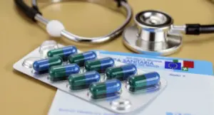Blister di capsule, tessera sanitaria italiana e stetoscopio su un tavolo