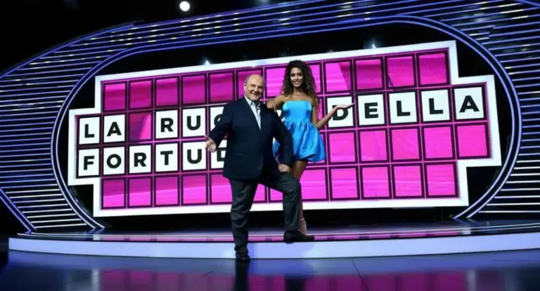 Due persone davanti al tabellone del programma La Ruota della Fortuna