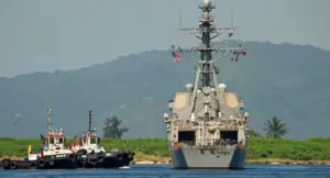 Nave militare statunitense ancorata vicino alla costa con barche di supporto